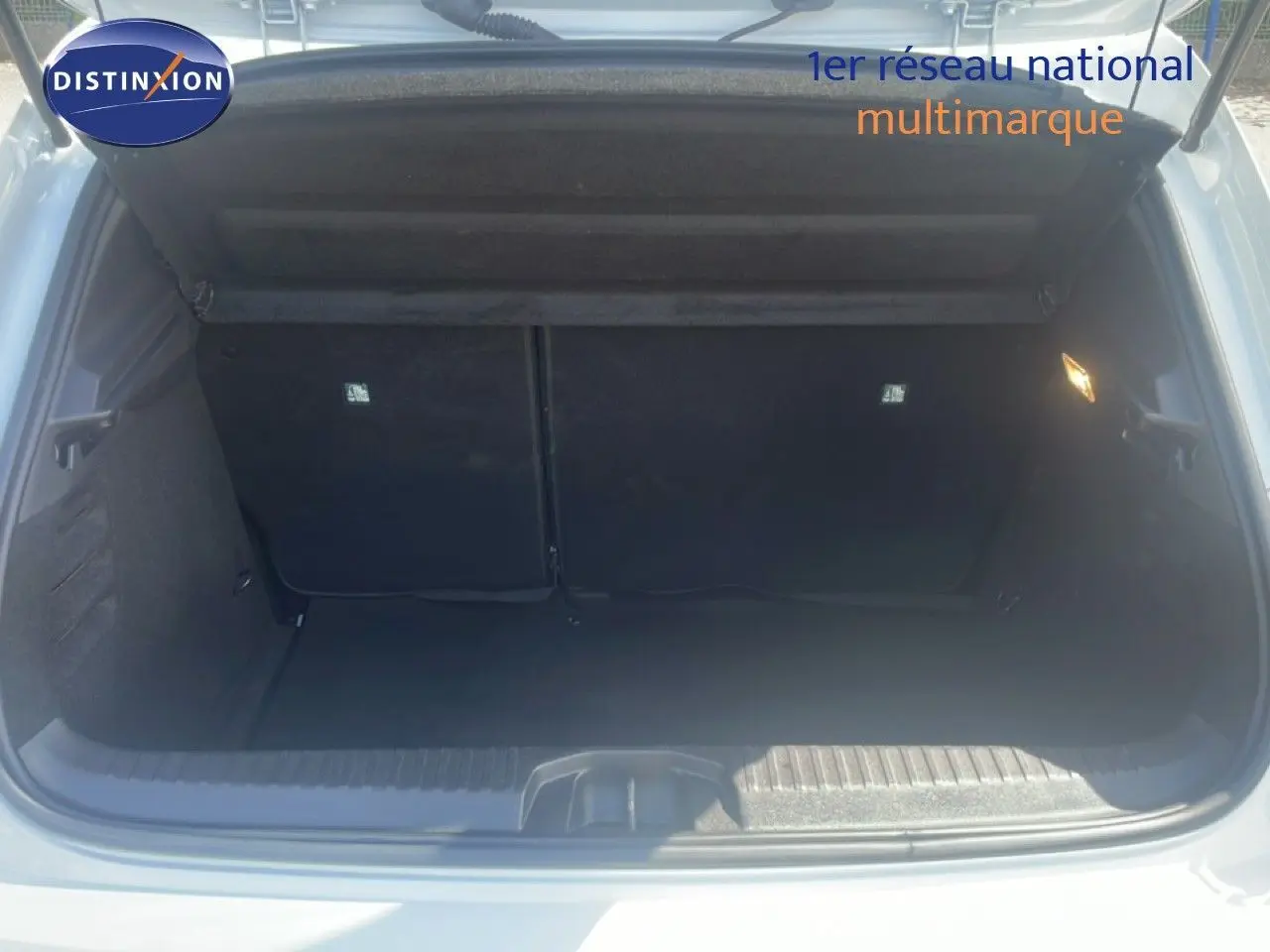 Coffre ouvert de la Renault Clio blanche 2025, vue de l'arrière montrant un espace de chargement vide et propre.