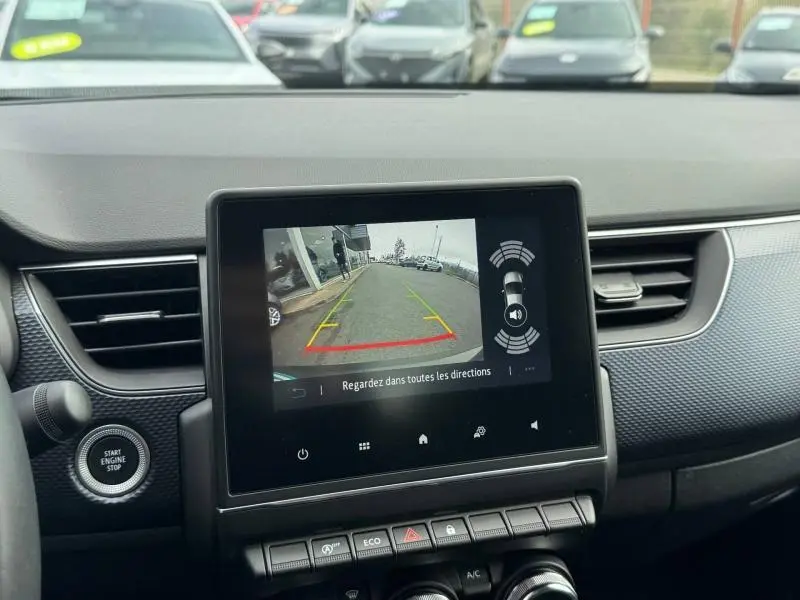 Vue intérieure du tableau de bord du Renault Arkana 2025, écran central affichant la caméra de recul avec lignes de guidage.