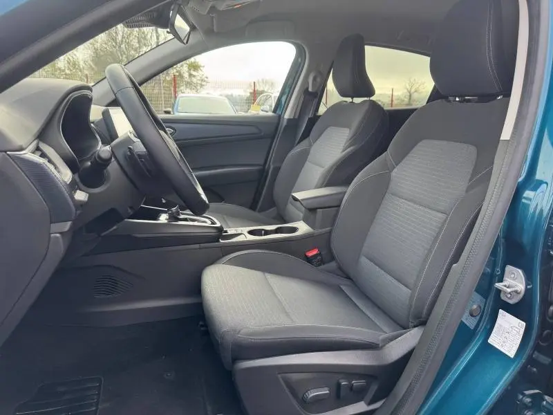 Vue intérieure côté conducteur du Renault Arkana 2025 bleu Zanzibar, montrant les sièges et la console centrale.