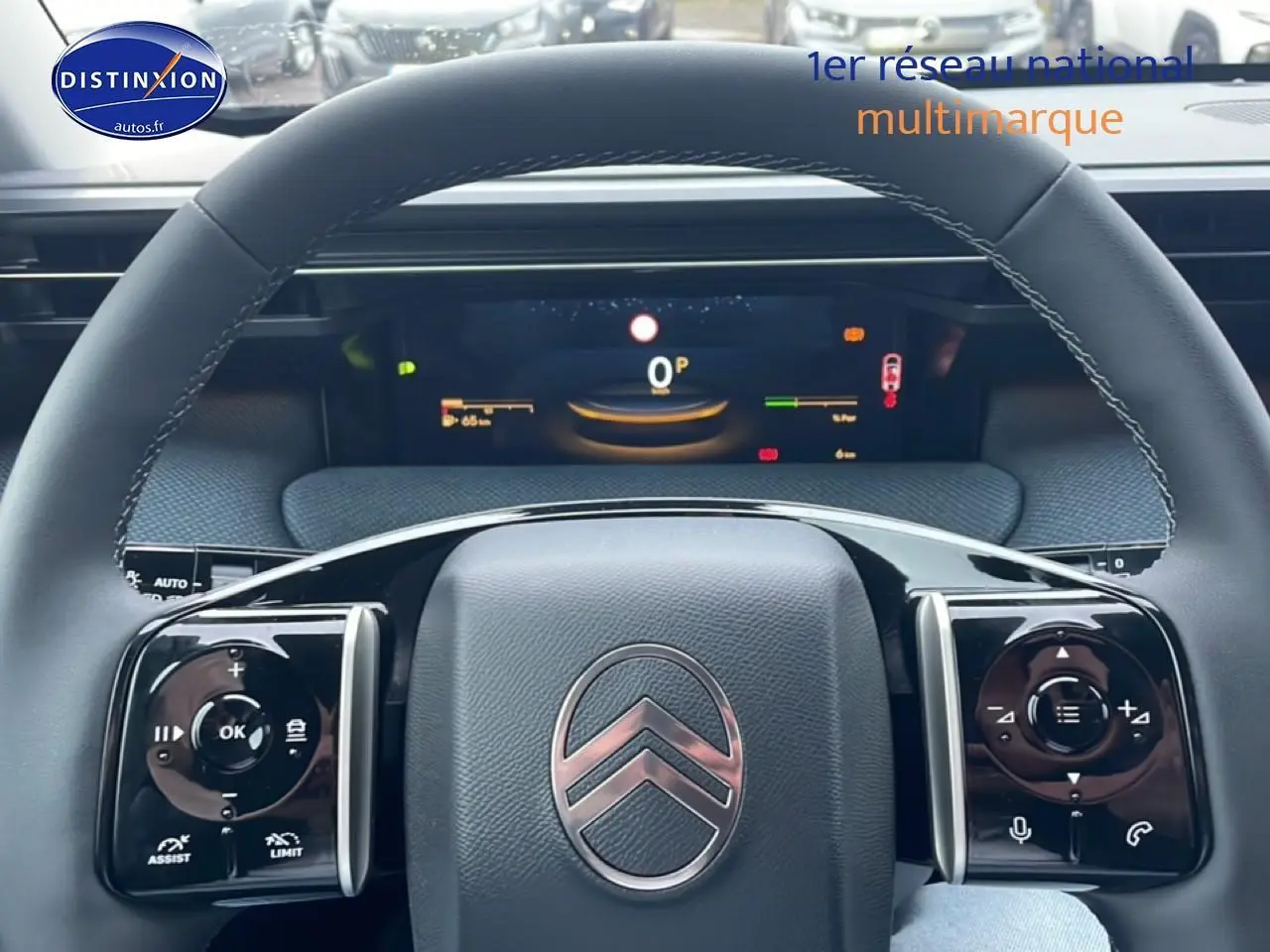 Vue rapprochée du volant noir multifonction avec logo Citroën et tableau de bord numérique du C5 Aircross hybride 2026.