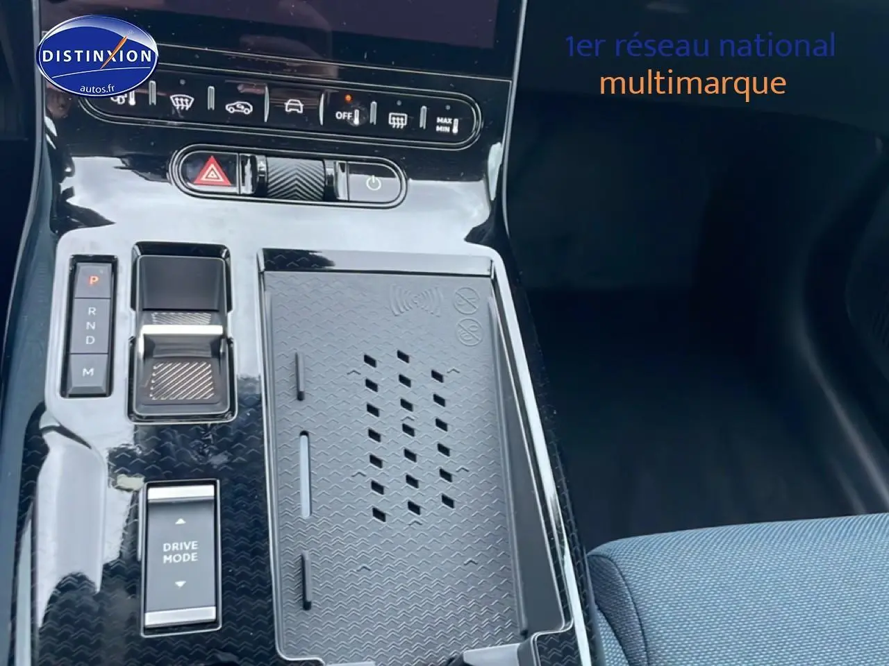 Vue rapprochée de la console centrale noire du Citroën C5 Aircross hybride avec commandes de boîte auto et chargeur sans fil.