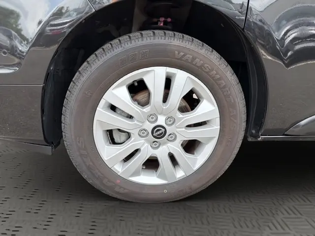 Gros plan sur la roue arrière droite noire du Nissan Primastar 2025, soulignant le pneu et l'aile du véhicule.