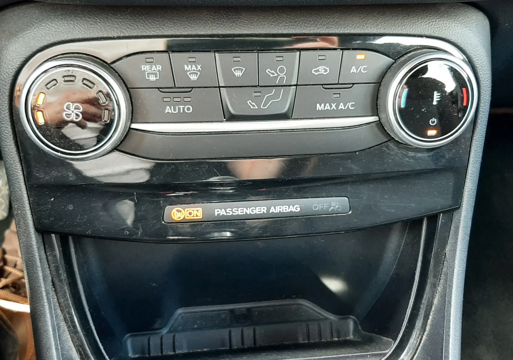 Gros plan sur la console centrale du Ford Puma 2022, montrant les commandes de climatisation et l'indicateur d'airbag passager.