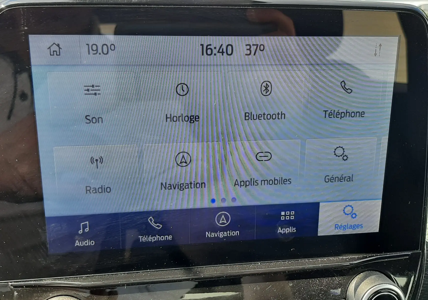 Écran tactile central du Ford Puma blanc 2022 montrant le menu des réglages avec commandes audio et navigation visibles.