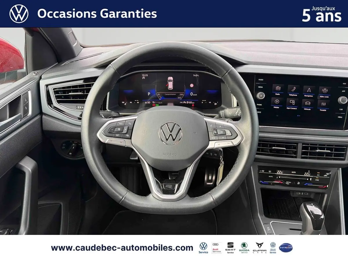 Vue intérieure centrée sur le volant cuir multifonctions et le tableau de bord digital de la Volkswagen Polo rouge 2025.
