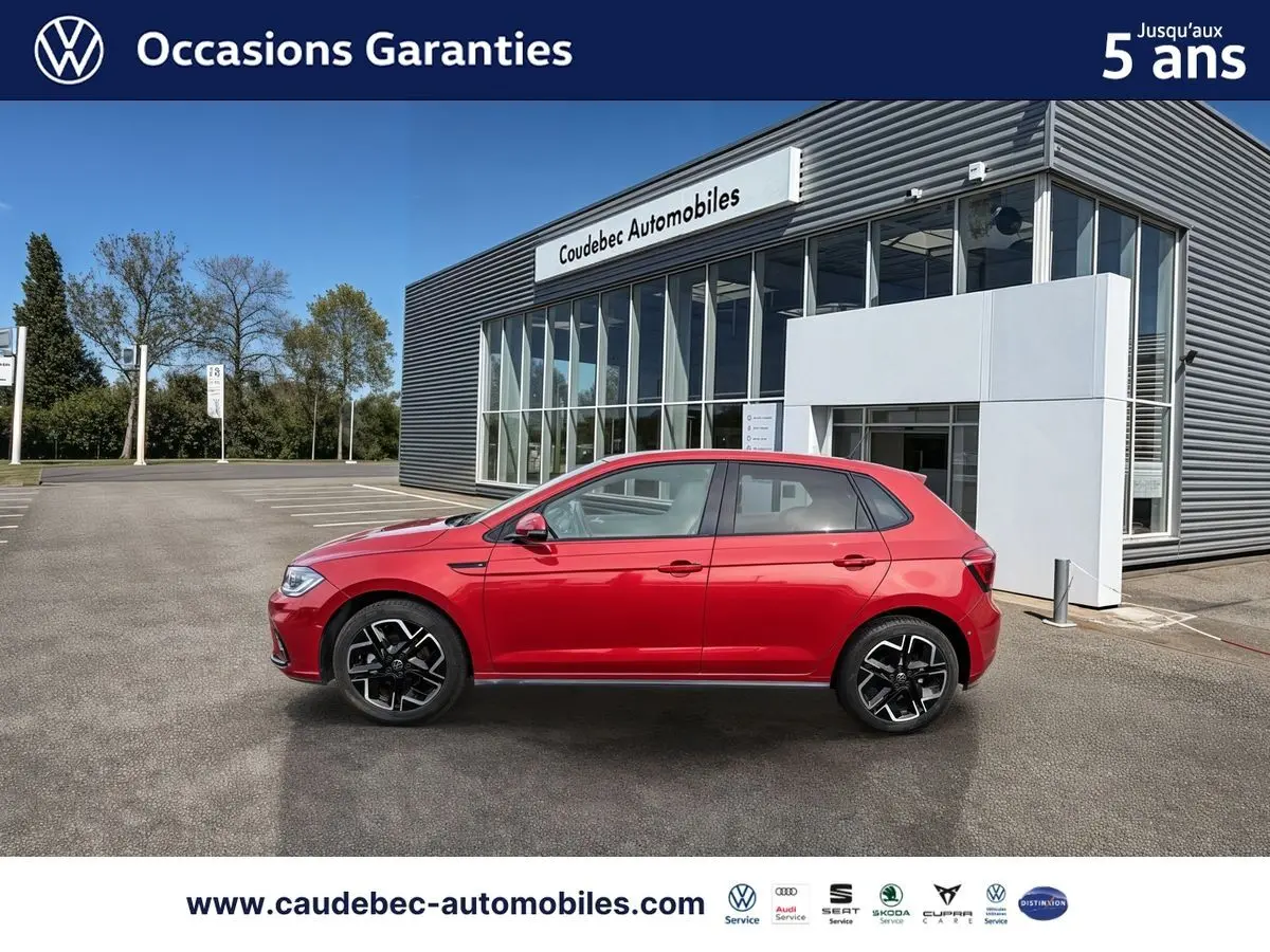 Profil droit d'une Volkswagen Polo rouge 2025 avec jantes alliage 17 pouces, stationnée devant un bâtiment moderne.