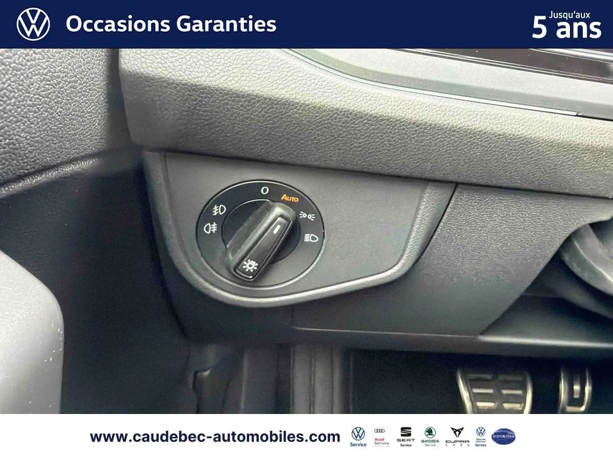 Gros plan sur le sélecteur d’éclairage intérieur de la Volkswagen Polo rouge, avec pédales en arrière-plan.