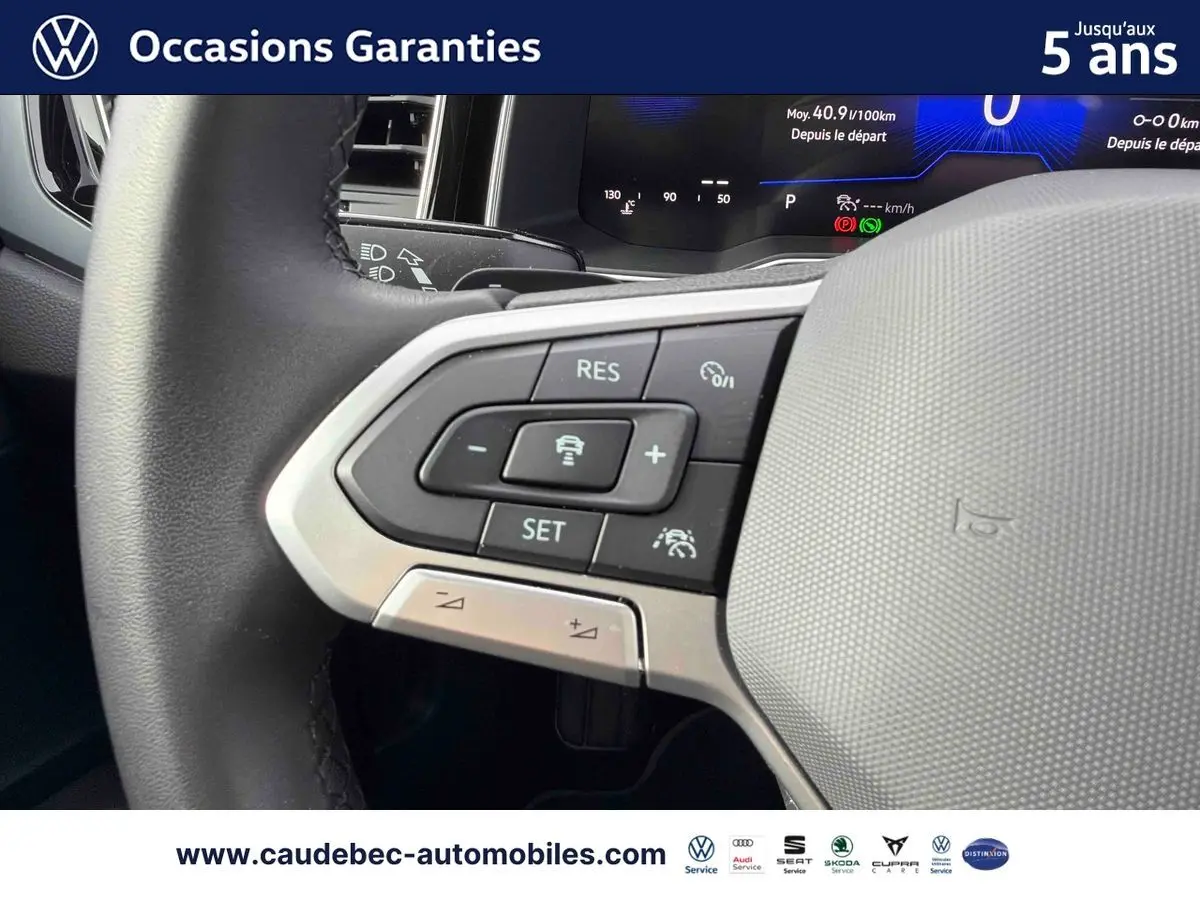 Gros plan sur le volant multifonctions noir de la Volkswagen Polo 2025 avec commandes de régulateur de vitesse.