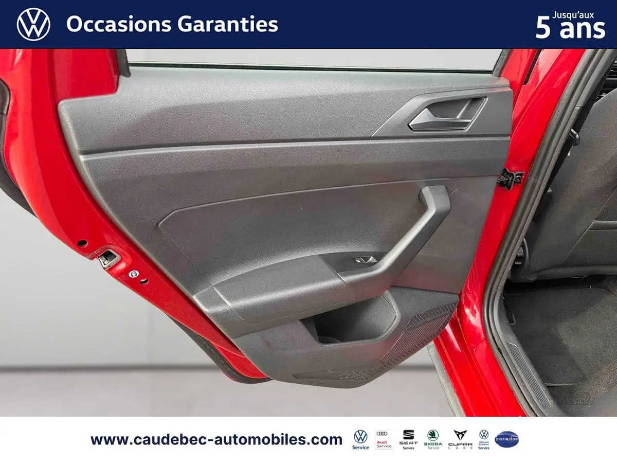 Vue rapprochée de la porte arrière gauche rouge du Volkswagen Polo 2025 avec intérieur noir et commande de fenêtre.