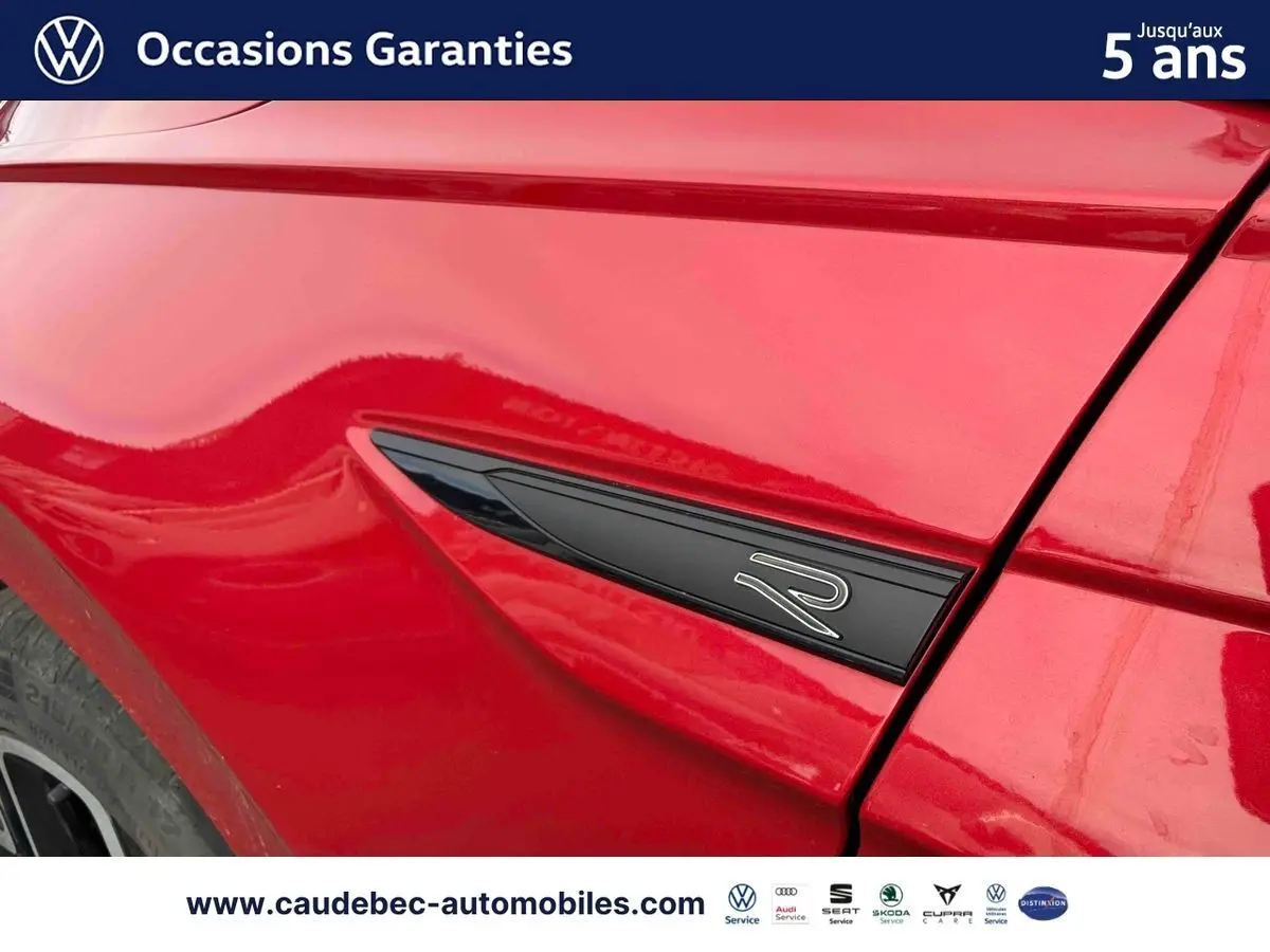 Détail du logo R sur l'aile avant gauche d'une Volkswagen Polo rouge 2025, finition sportive R-Line.