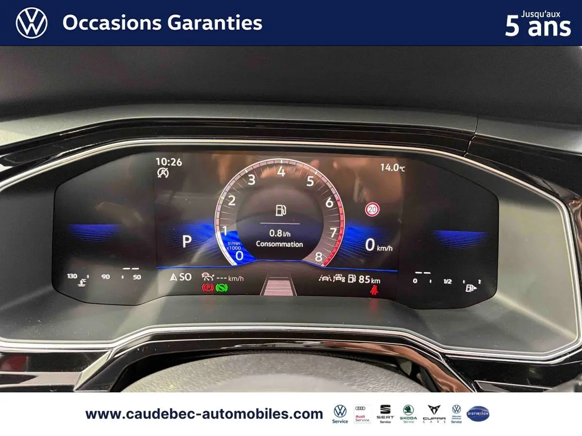 Vue rapprochée du combiné d'instruments digital de la Volkswagen Polo rouge, affichant la consommation et la vitesse à 0 km/h.