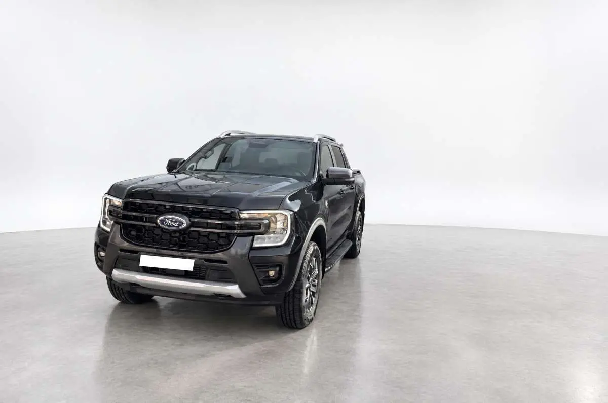 Ford Ranger 2026 noir agate vu en 3/4 avant droit, avec calandre noire et jantes alu 18 pouces visibles.