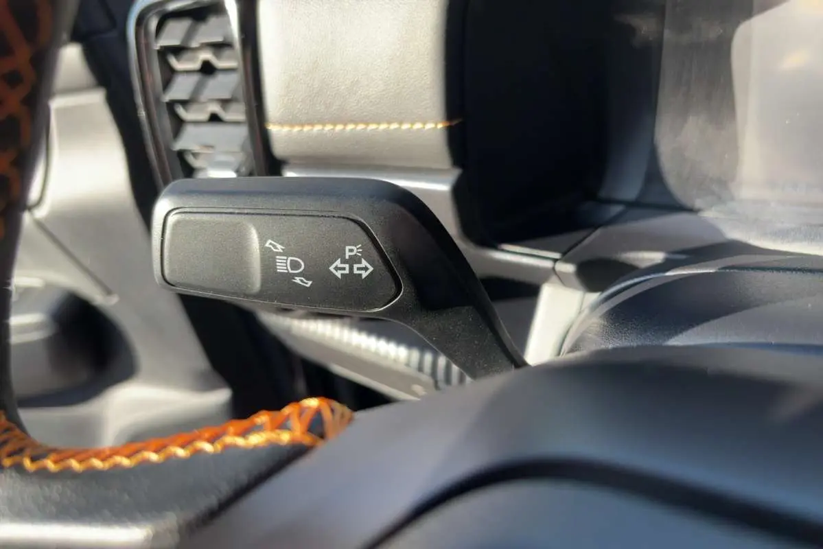 Gros plan sur la commande de clignotants du Ford Ranger Wildtrak 2026, volant cuir noir avec surpiqûres orange.