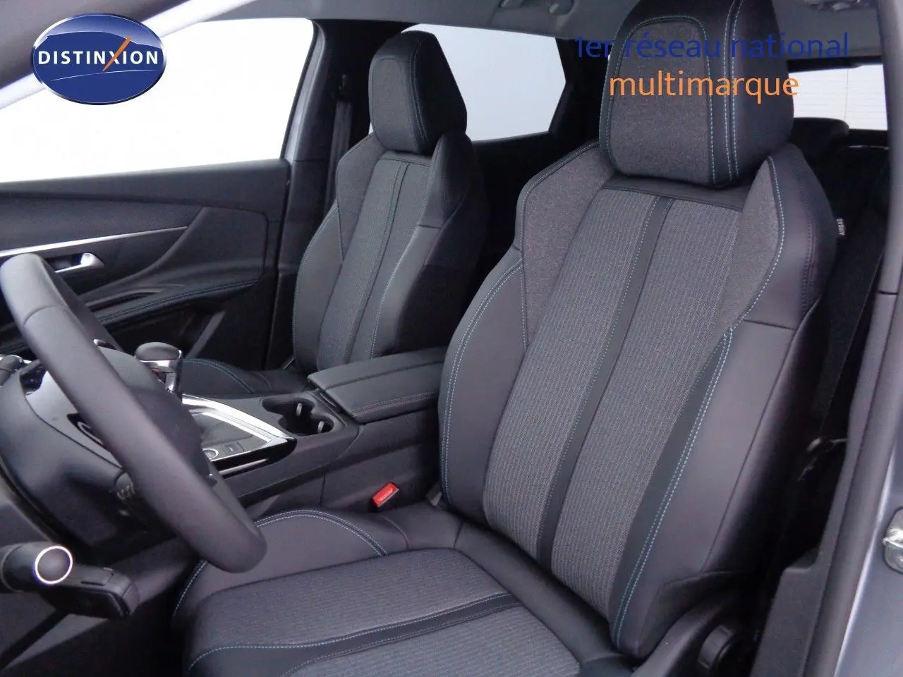 Intérieur du Peugeot 3008 2023, vue côté conducteur, sièges en cuir noir avec surpiqûres bleues et tissu gris.