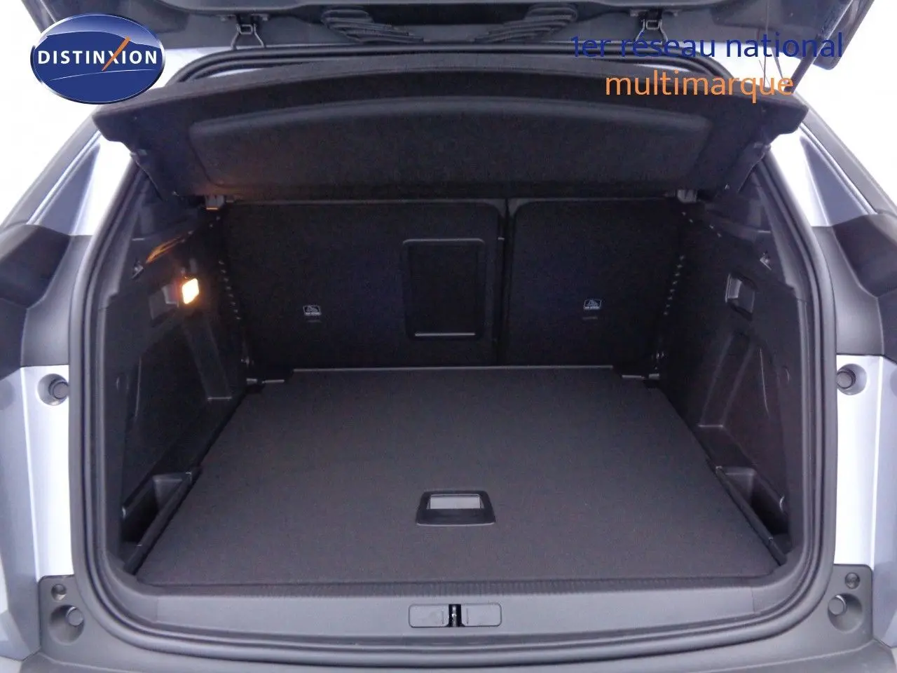 Coffre ouvert du Peugeot 3008 gris Artense Metal, montrant un espace de chargement spacieux et bien agencé.