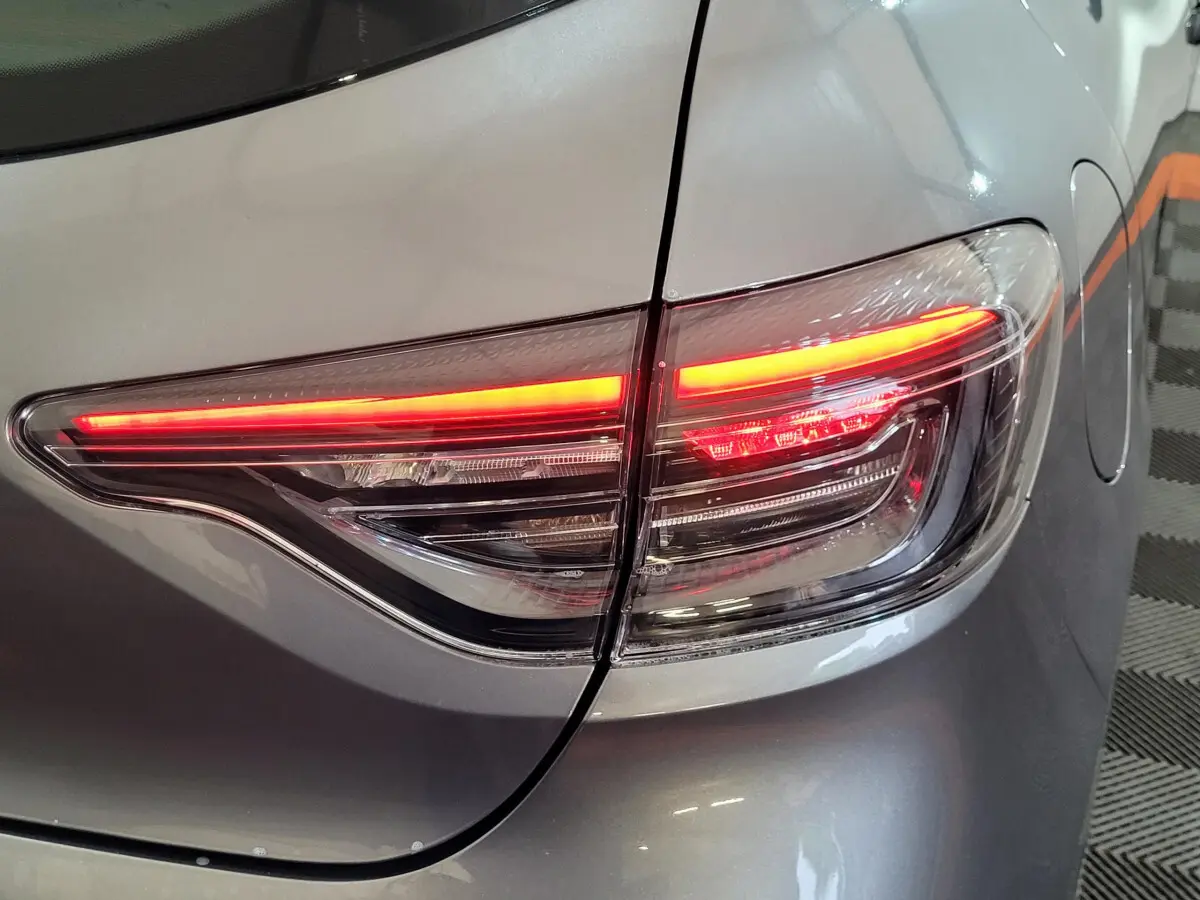 Gros plan sur le feu arrière droit allumé d'une Renault Clio gris foncé Evolution Blue dCi 100 -25 de 2025.