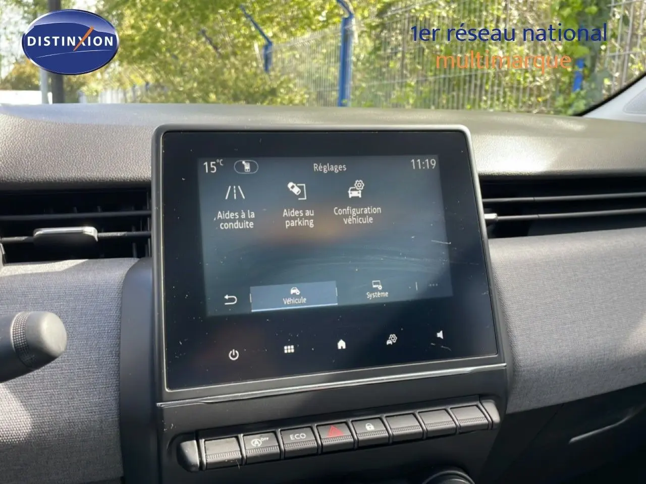 Vue rapprochée de l’écran tactile central de la Renault Clio gris schiste, affichant les réglages d’aides à la conduite et parking.