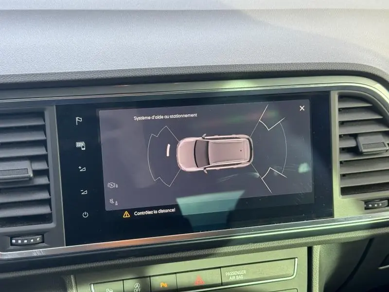 Écran tactile central du tableau de bord du SEAT Ateca noir, affichant l’aide au stationnement vue de dessus.