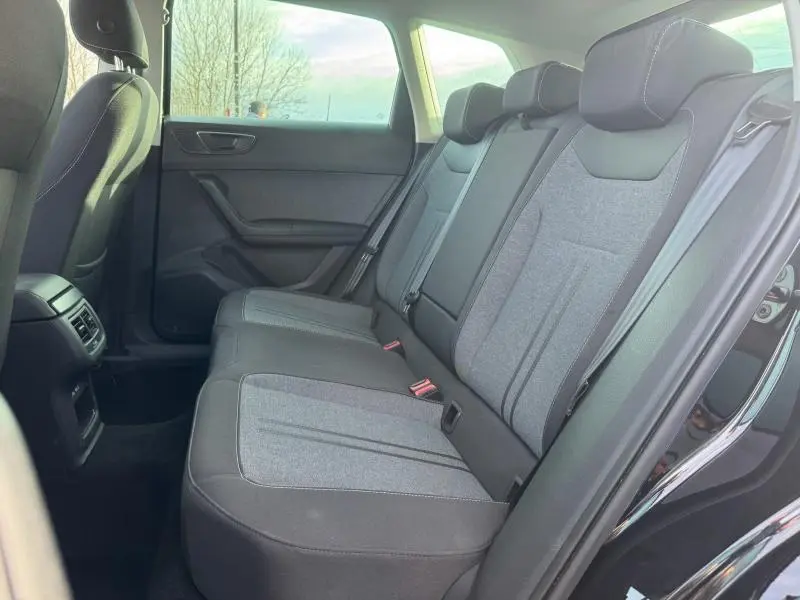 Vue latérale droite de la banquette arrière grise et noire du SEAT Ateca 2024 Noir Magique Métal avec ceintures et appuie-têtes.
