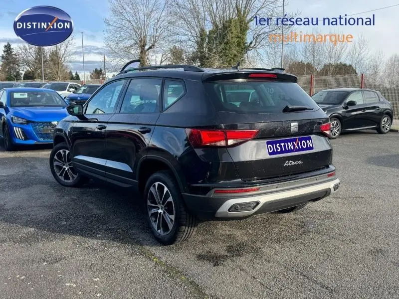Vue 3/4 arrière droite d'un SEAT Ateca 2024 noir métallique avec jantes alliage et feux arrière LED visibles.