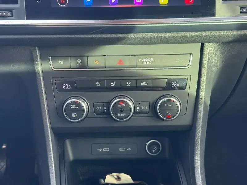 Vue rapprochée de la console centrale noire du SEAT Ateca 2024, avec commandes climatisation et boutons multifonctions.