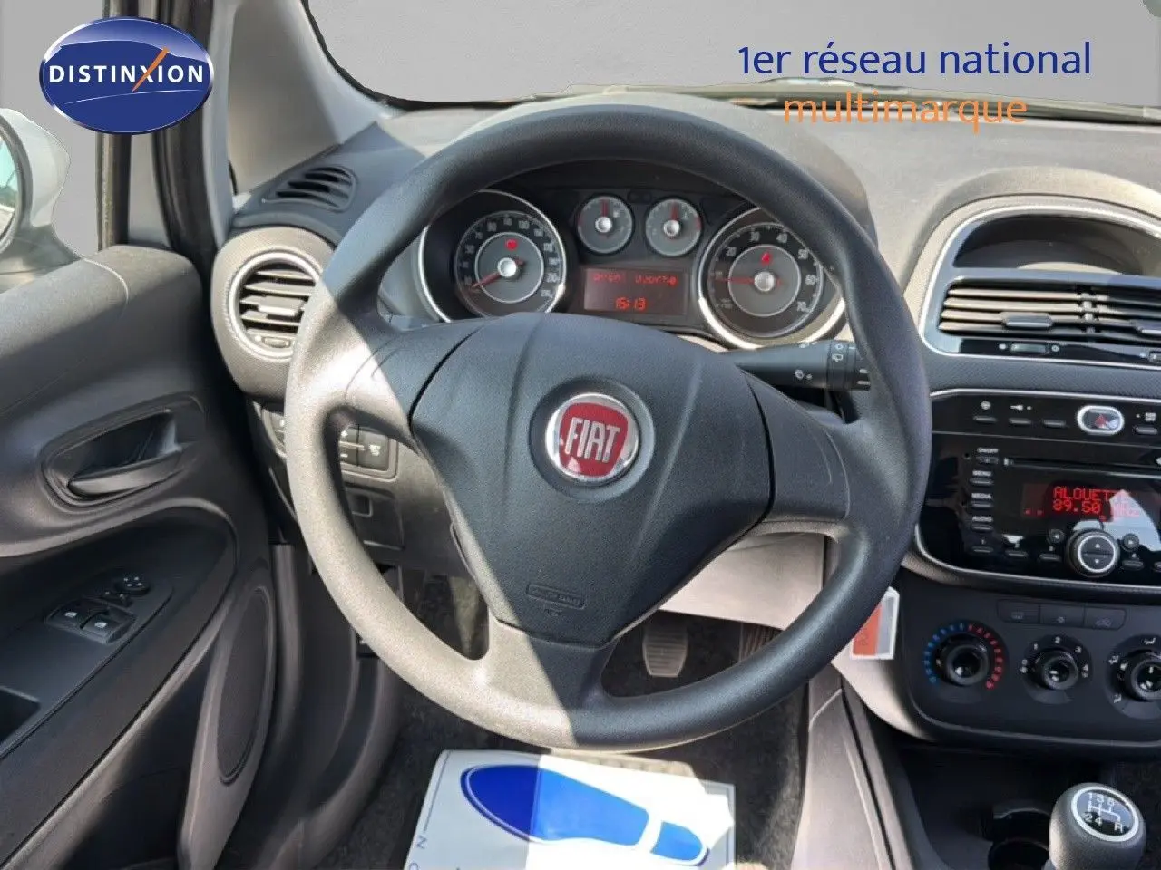 Vue intérieure centrée sur le volant Fiat d'une Punto Street 2016, avec tableau de bord et commandes visibles.