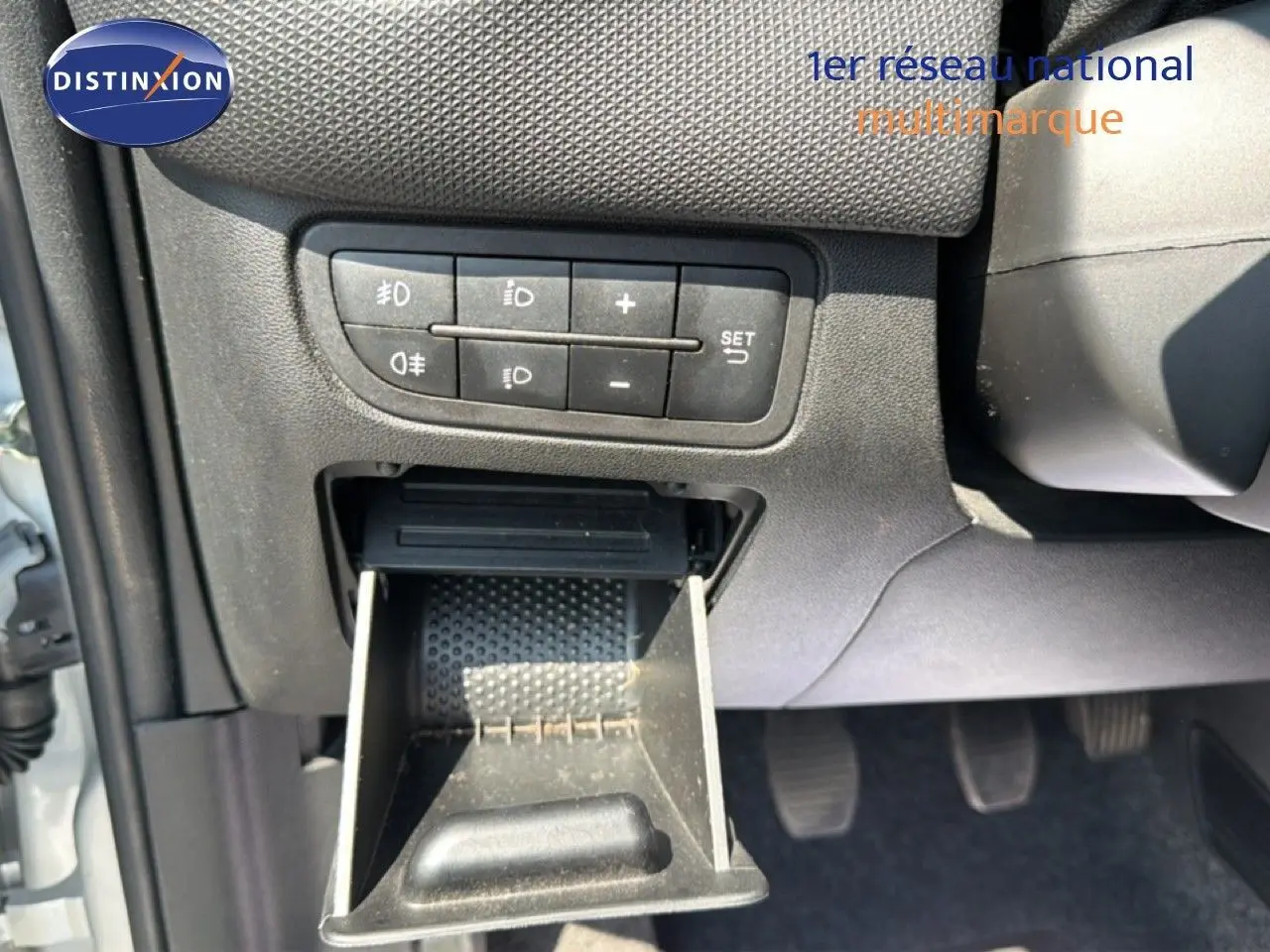 Gros plan sur le tableau de bord côté gauche d'une Fiat Punto Street gris argent de 2016 avec commandes d'éclairage et cendrier ouvert.