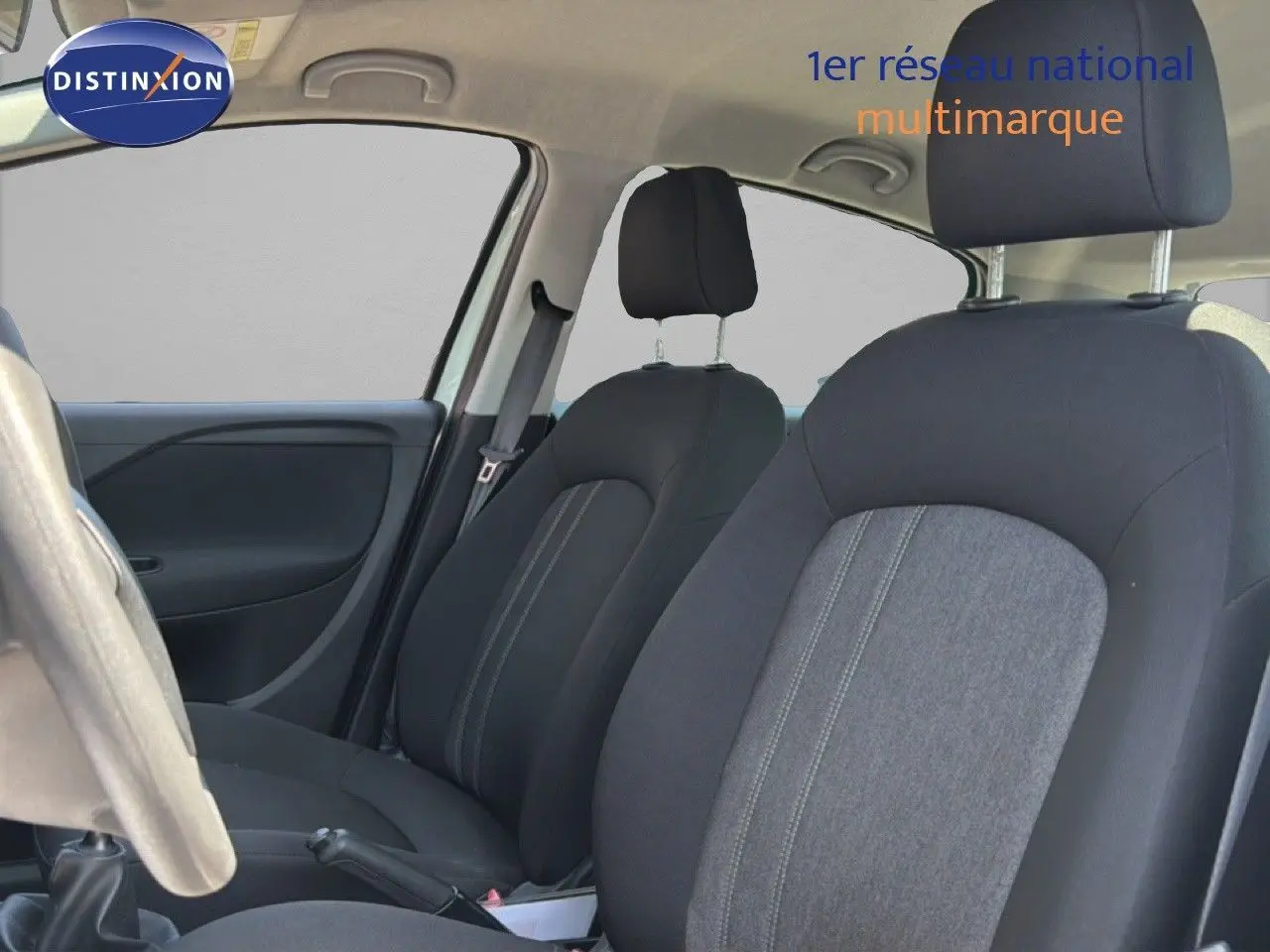 Vue intérieure côté conducteur montrant les sièges avant en tissu noir et gris de la Fiat Punto Street 2016.