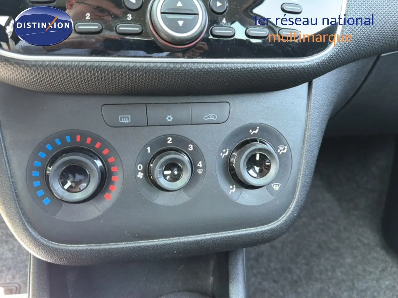 Vue rapprochée des commandes de climatisation d'une Fiat Punto Street gris argent de 2016, avec réglages manuels.