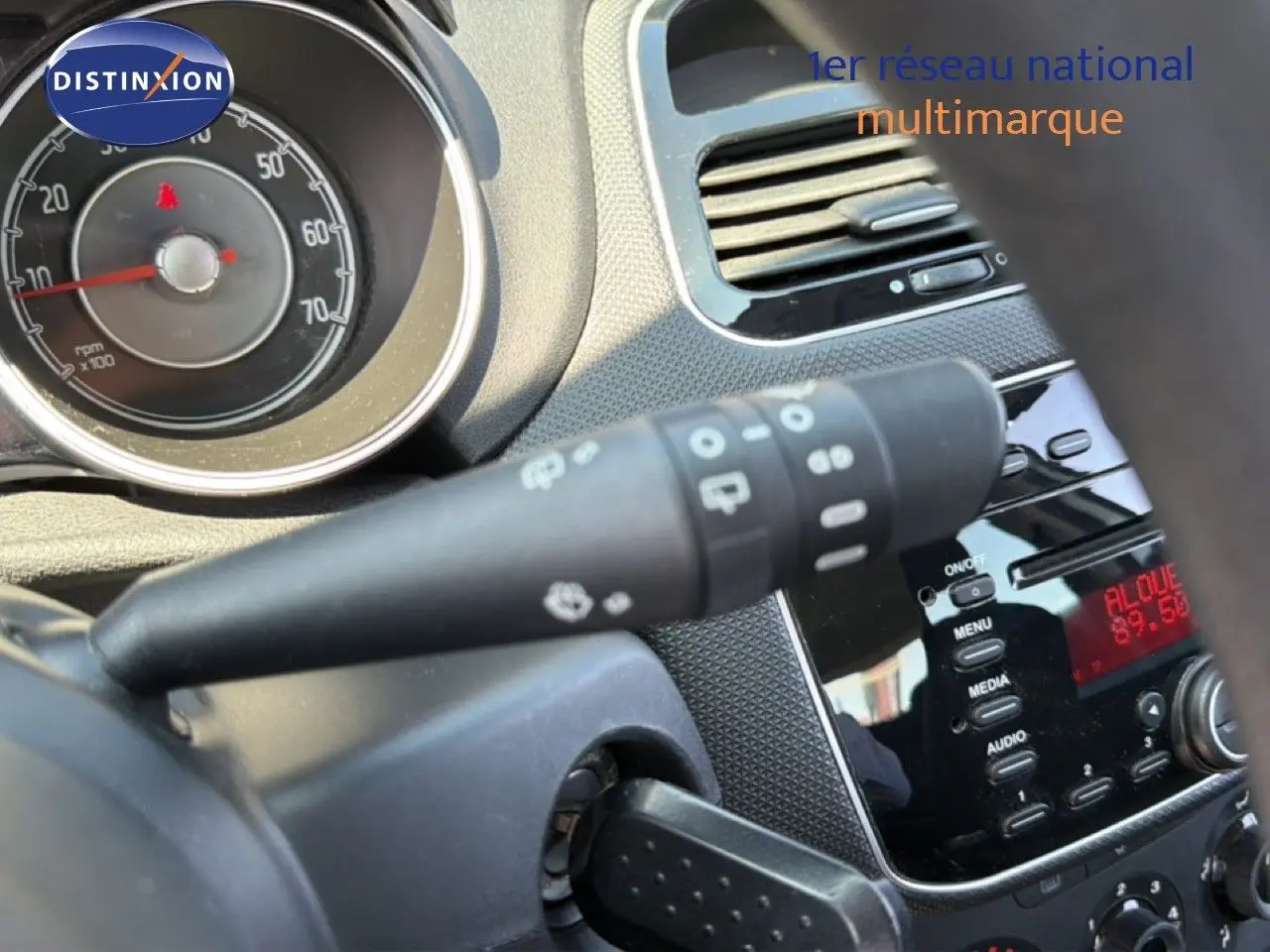 Gros plan sur le tableau de bord intérieur de la Fiat Punto gris argent, montrant les commandes et l'affichage radio.