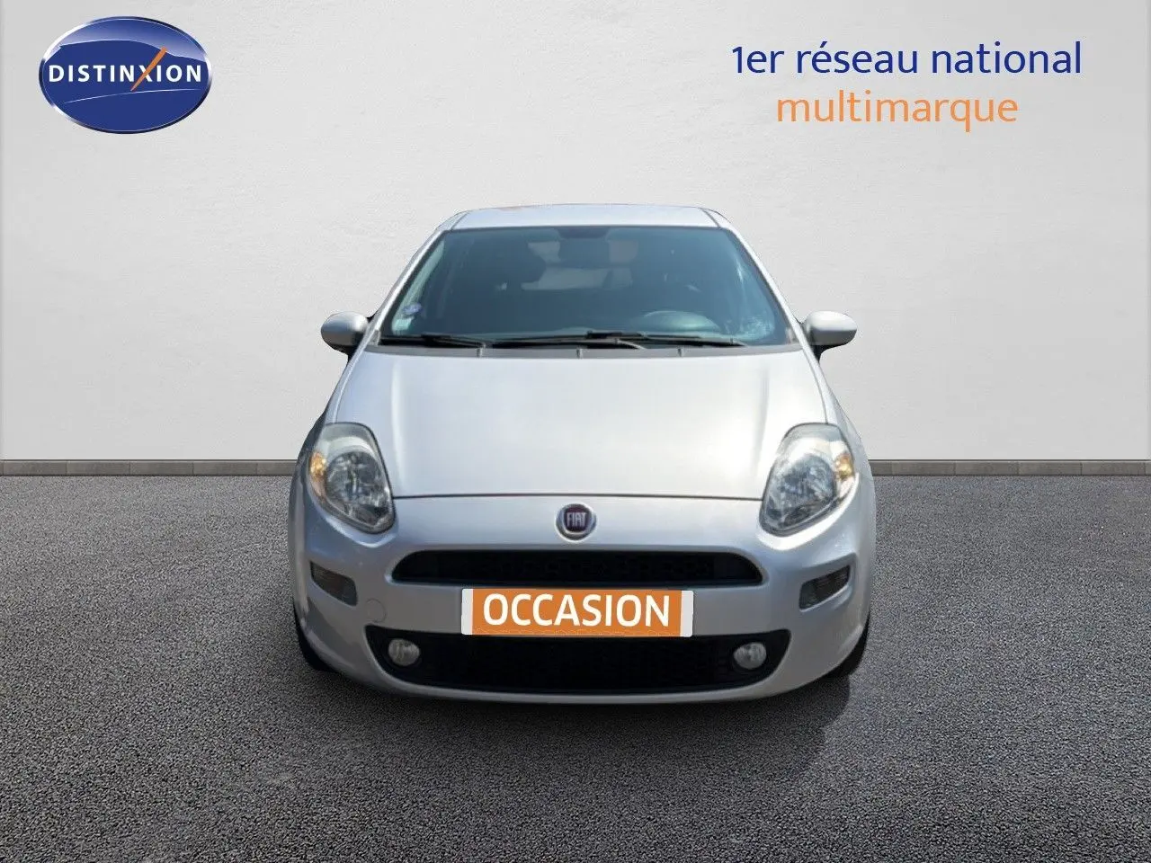 Vue frontale d'une Fiat Punto Street 2016 gris argent avec plaque "OCCASION" et phares allumés.