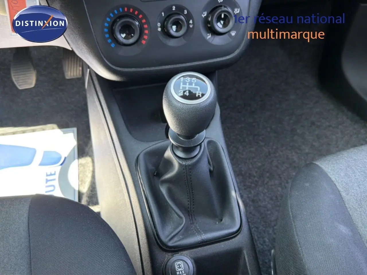 Vue rapprochée de la console centrale d'une Fiat Punto gris argent 2016, mettant en valeur le levier de vitesse manuel.