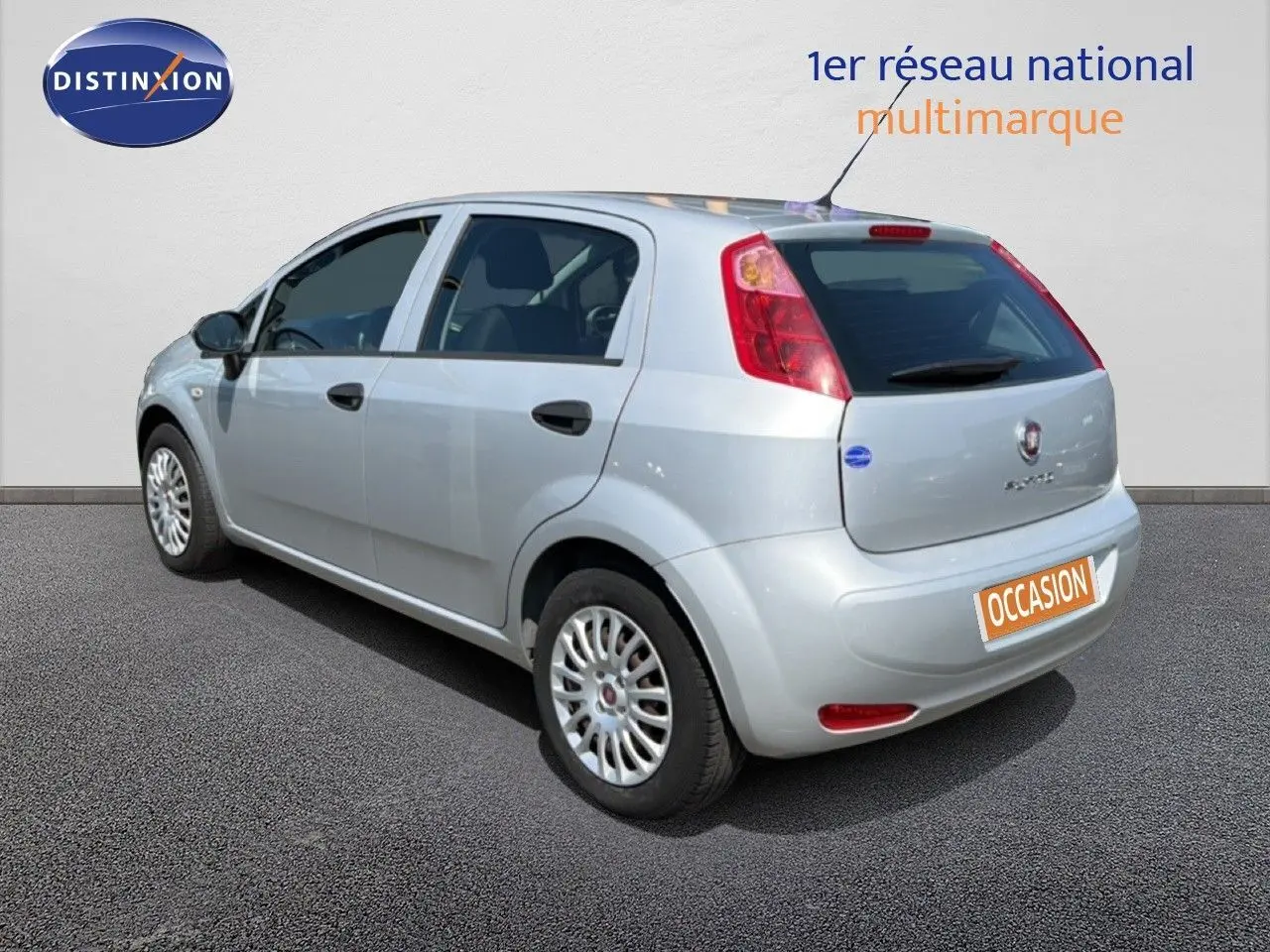 Vue 3/4 arrière droite d'une Fiat Punto Street gris argent 5 portes, avec jantes alliage et feux arrière rouges.