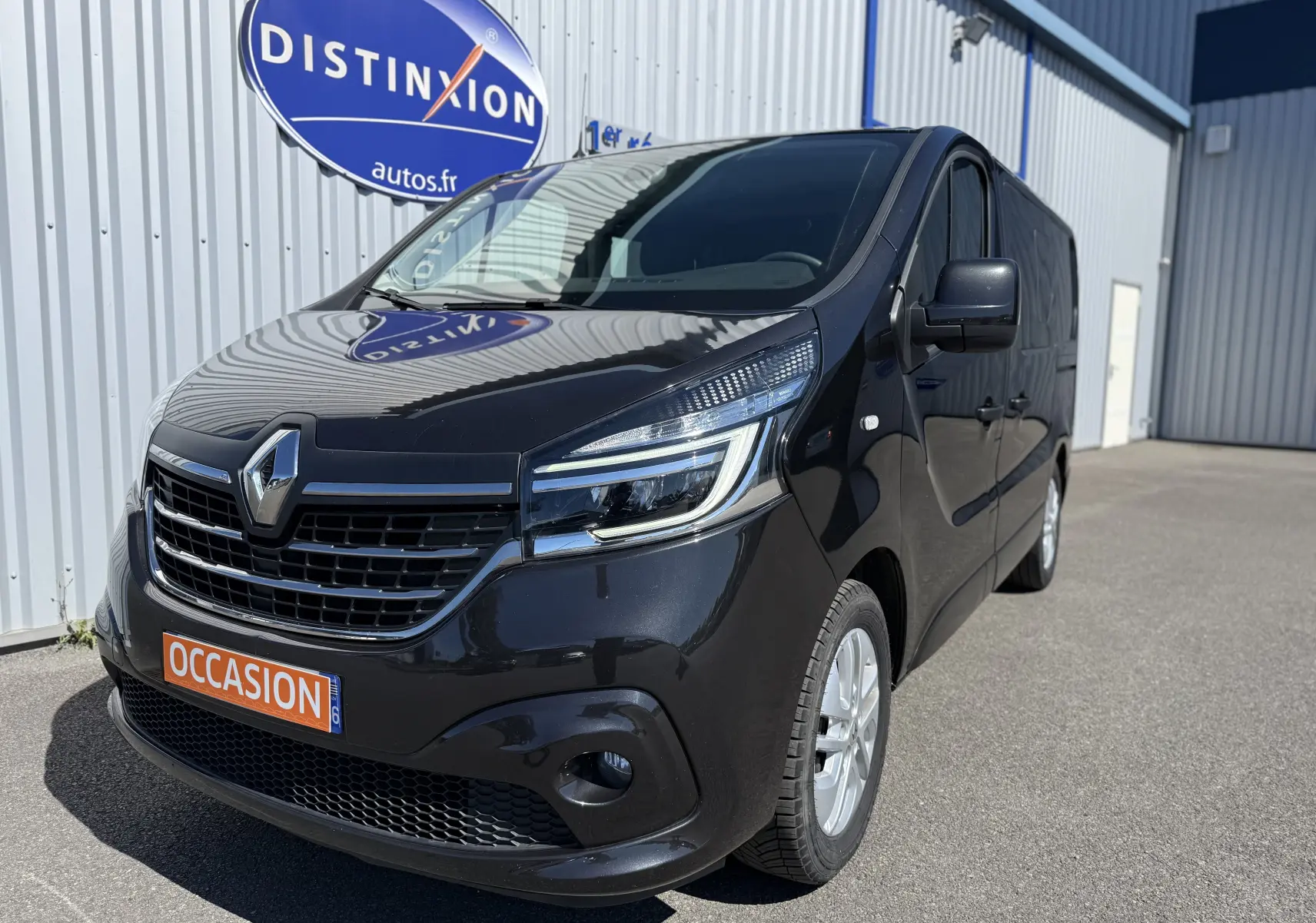 Renault Trafic cabine approfondie gris, vue 3/4 avant droit, avec calandre noire et phares LED distinctifs.