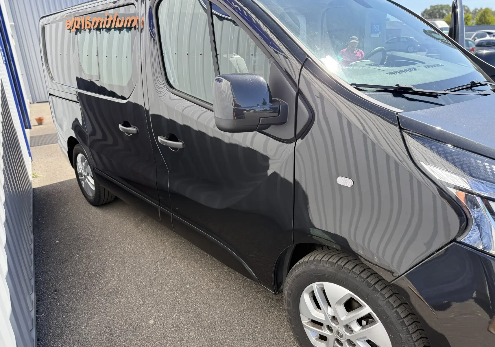 Vue de côté droit avant d’un Renault Trafic cabine approfondie gris 2021 avec jantes alliage et vitres teintées.