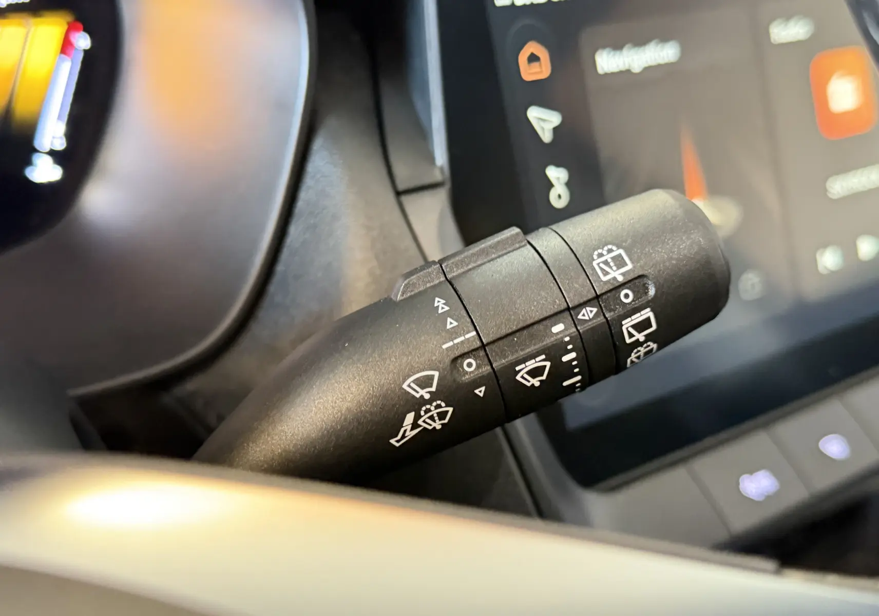 Gros plan sur la commande des essuie-glaces du MG ZS 1.5 L Hybrid+ 2026 avec écran tactile en arrière-plan.