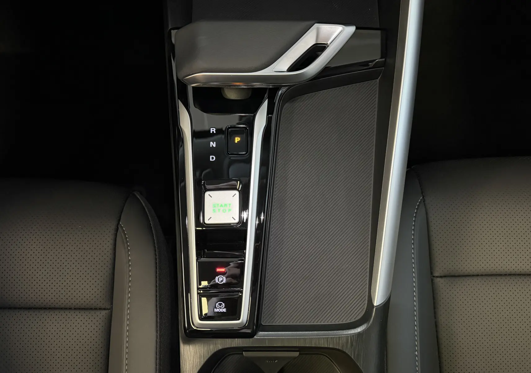 Vue plongeante sur la console centrale noire du MG ZS 2026 avec levier de vitesses automatique et bouton start/stop éclairé.