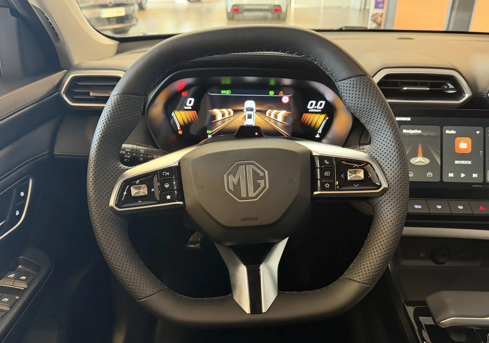 Vue centrée sur le volant en cuir perforé noir d’un MG ZS 2026 avec tableau de bord numérique et écran tactile.