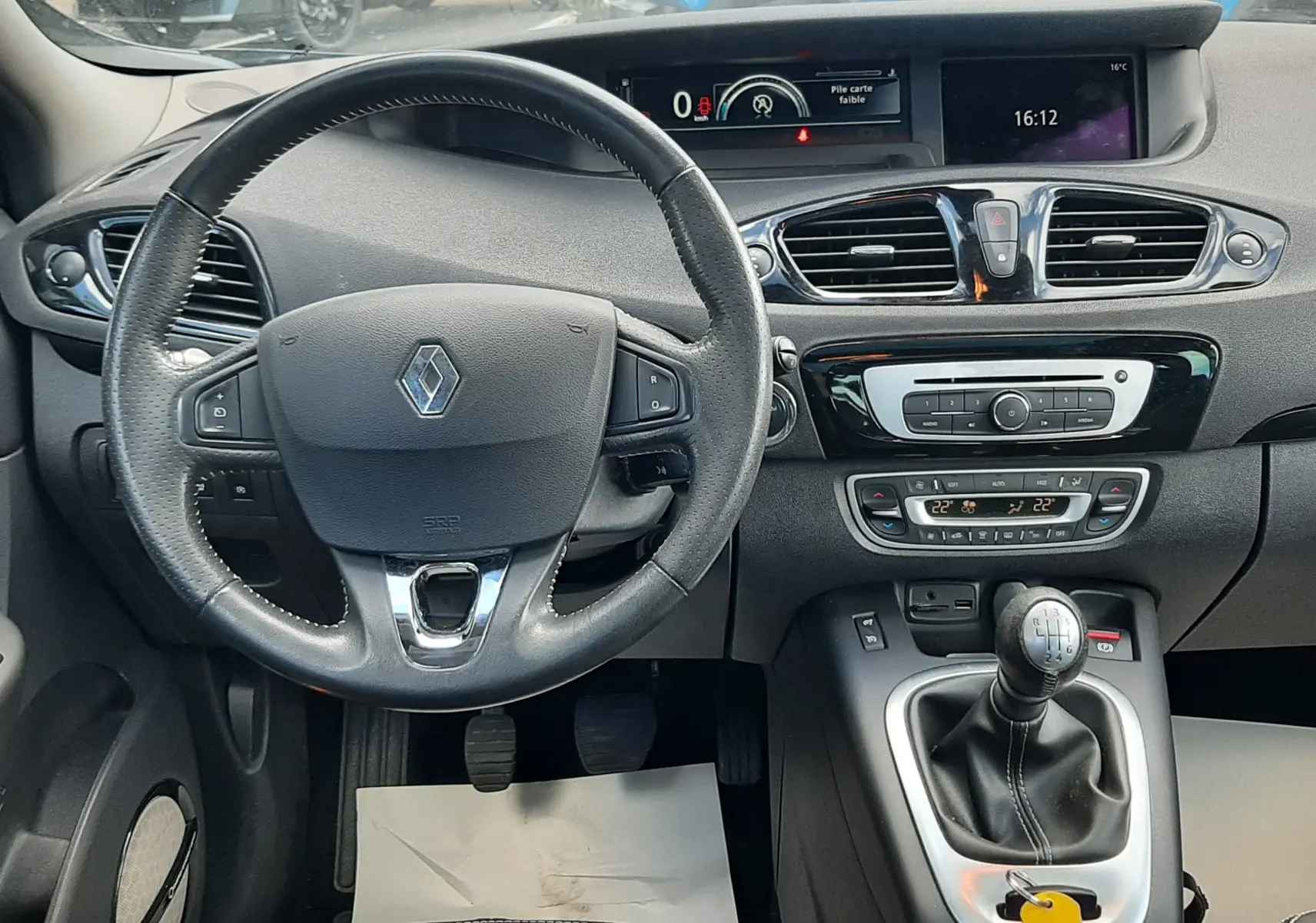 Vue intérieure avant du tableau de bord noir du Renault Grand Scenic DCI 110 Bose 7 places avec volant cuir, écran digital et boîte manuelle.