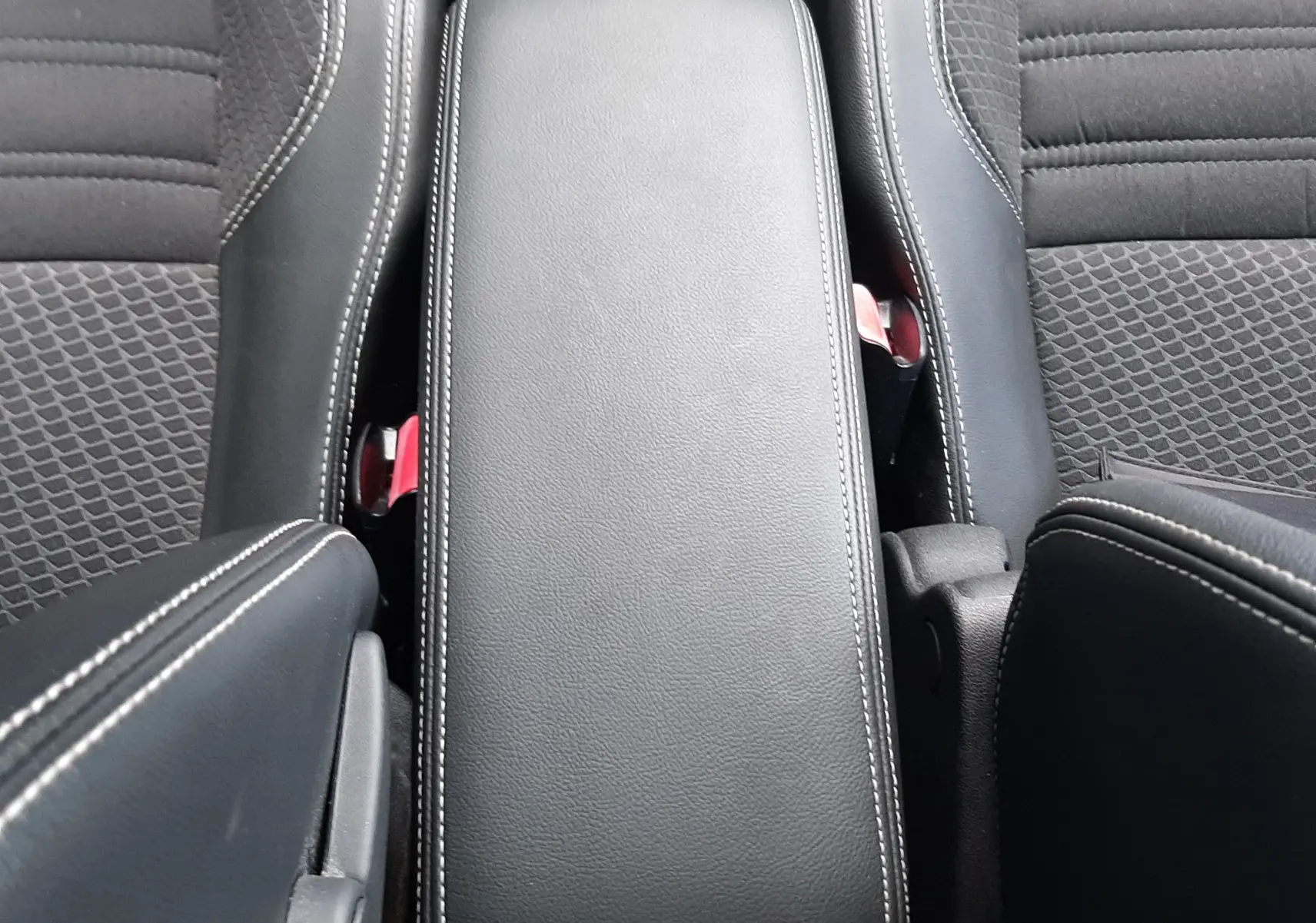 Vue plongeante sur l'accoudoir central en cuir noir avec surpiqûres blanches du Renault Grand Scenic DCI 110 Bose 7 places.