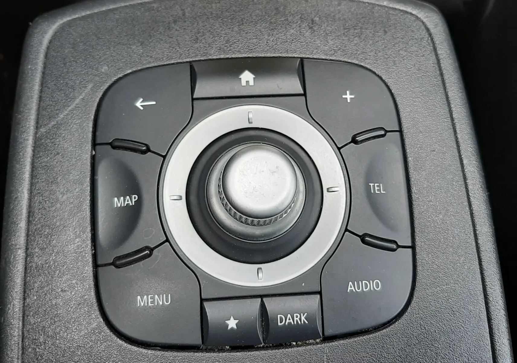 Gros plan sur la molette de commande centrale noire du Renault Grand Scénic DCI 110 Bose 7 places de 2015.