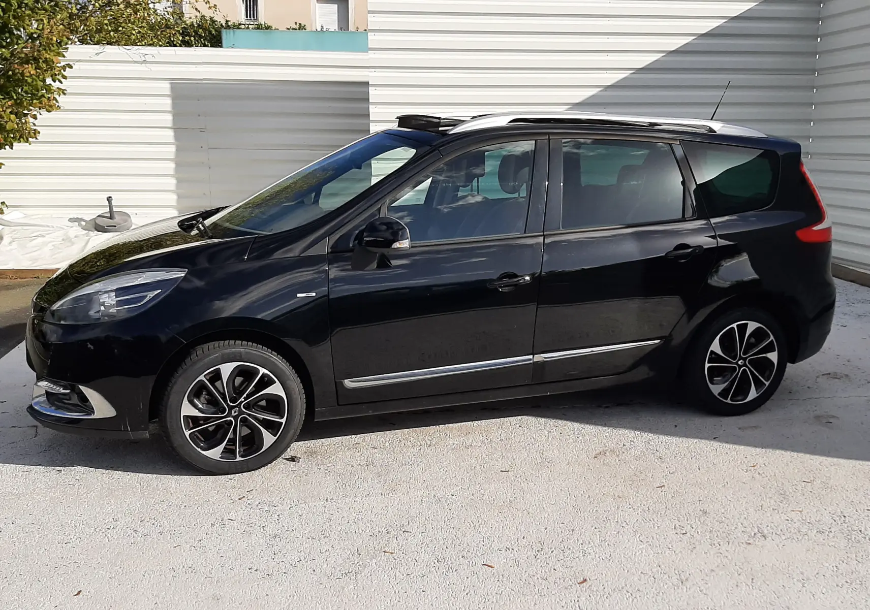 Renault Grand Scenic noir vue de profil côté gauche, monospace 7 places avec jantes alliage bicolores.