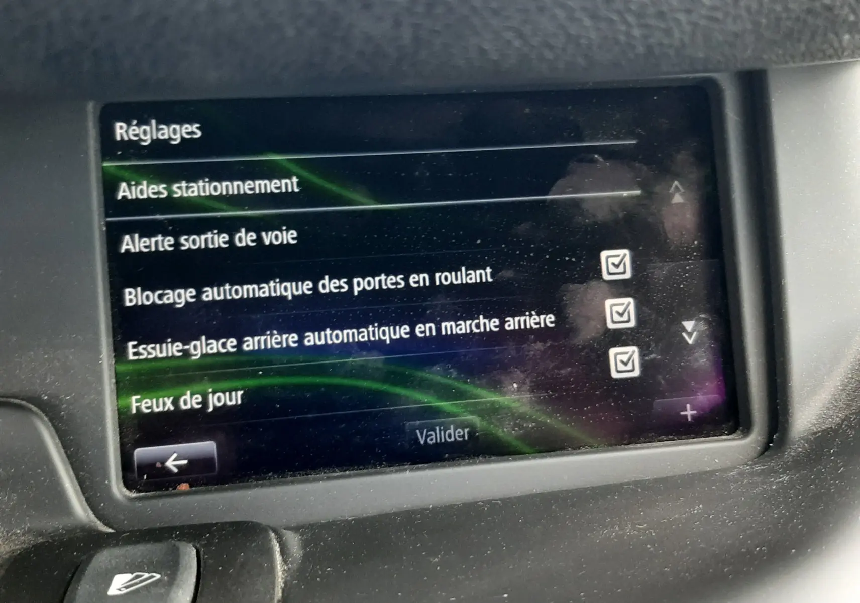 Écran tactile du tableau de bord du Renault Grand Scenic noir 2015 affichant les réglages d’aides à la conduite.