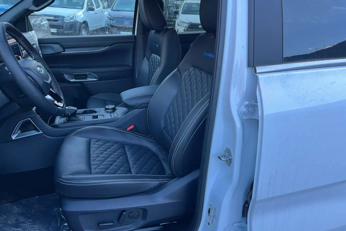 Vue côté conducteur intérieur du Ford Ranger blanc glacier 2026, sièges cuir noirs matelassés avec logo Platinum Rideau.