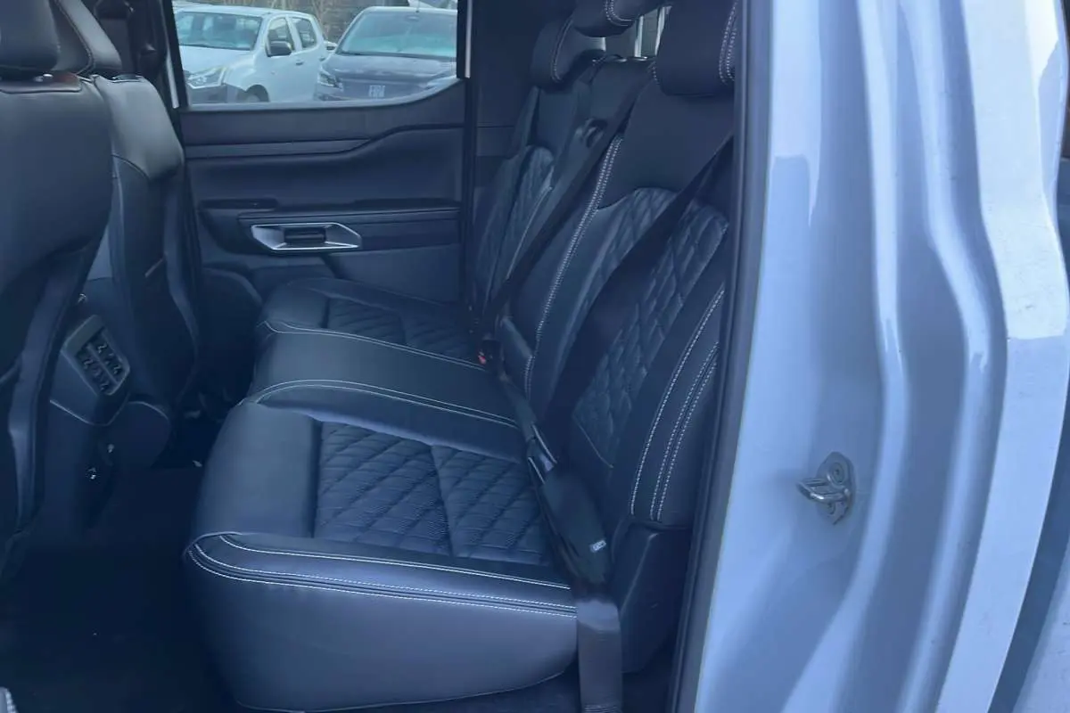 Vue intérieure côté droit sur les sièges arrière en cuir noir matelassé du Ford Ranger blanc glacier 2026.