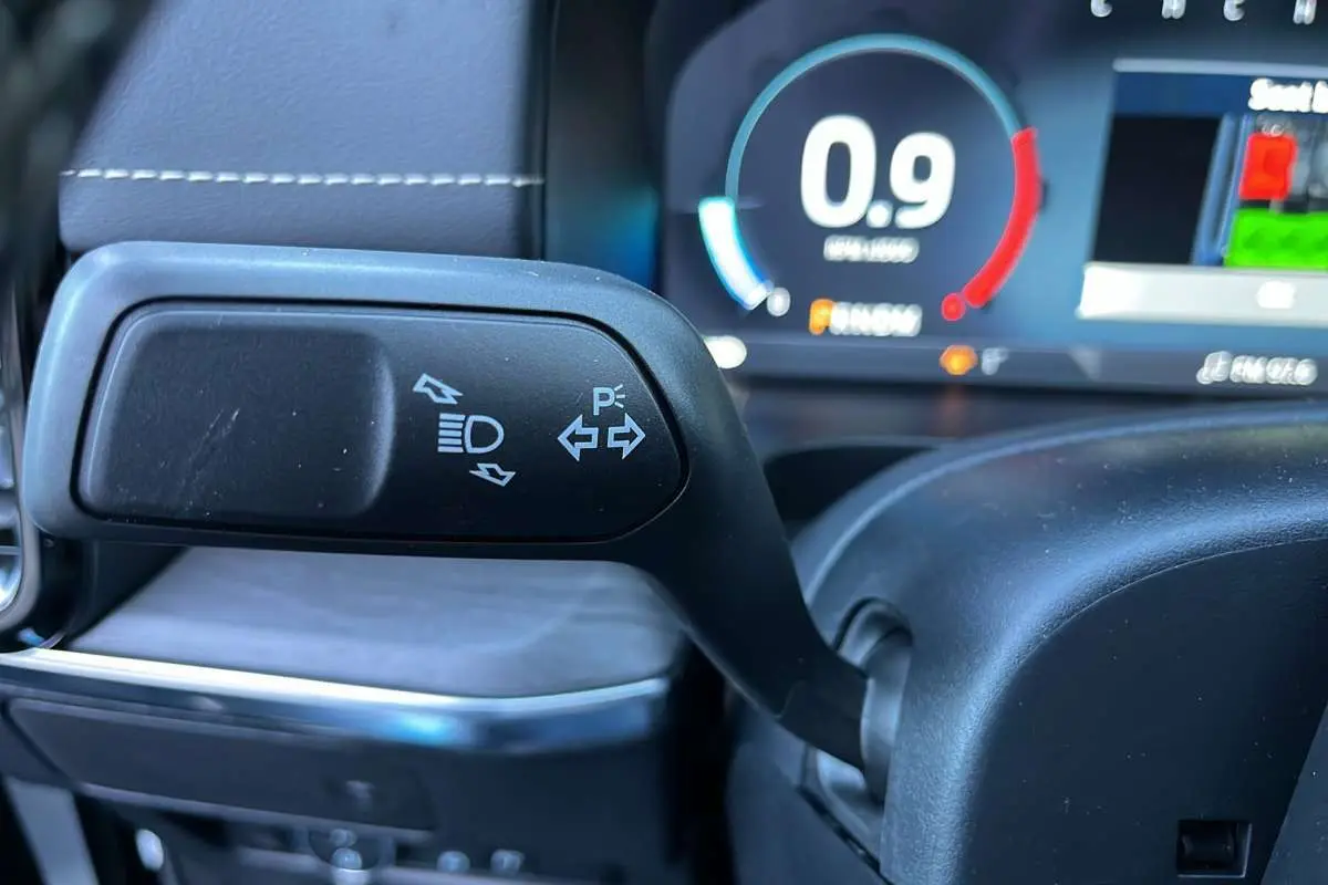 Gros plan sur la commande des feux et clignotants du Ford Ranger 2026, avec tableau de bord numérique en arrière-plan.