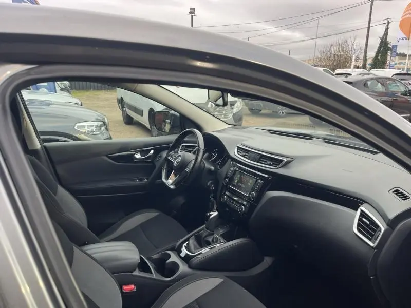 Intérieur du Nissan Qashqai gris Squale 2020, vue côté conducteur, volant cuir multifonction et console centrale avec écran tactile.