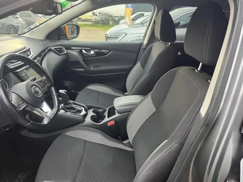 Intérieur avant du Nissan Qashqai gris Squale, sièges tissu noir et gris, volant cuir multifonction et console centrale avec boîte auto.