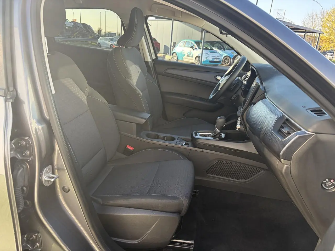 Vue intérieure côté conducteur de la Renault Arkana 2025, sièges noirs et console centrale avec boîte automatique.