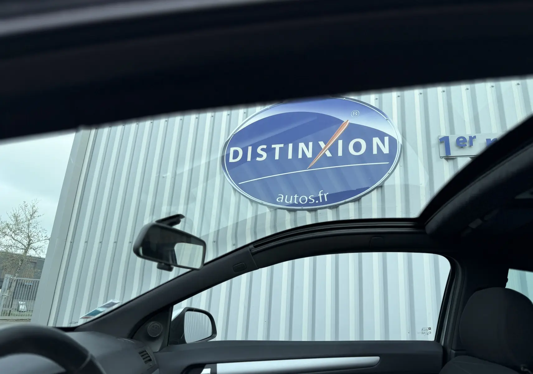 Vue intérieure côté gauche de l’Opel Astra gris 2010, avec toit ouvrant panoramique et rétroéclairage électrique visible.